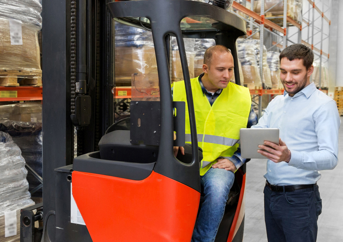 men with tablet pc and forklift at warehouse